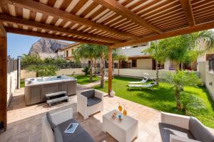 a patio with a hot tub in a yard at Samira in San Vito lo Capo