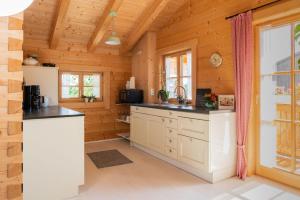 a kitchen in a log cabin with a sink and a counter at Alchemilla in Bad Feilnbach