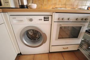 a kitchen with a washing machine and a stove at Comfortable, very well located between train station and lake! in Lausanne