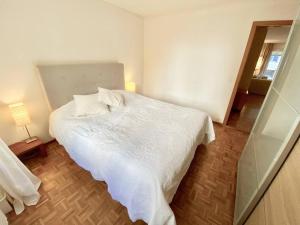 a bedroom with a white bed in a room at Comfortable, very well located between train station and lake! in Lausanne