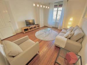 a living room with two couches and a television at Your bright charming cocoon between lake and city in Lausanne