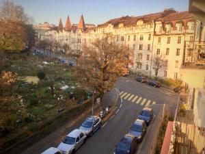 a street with cars parked in front of a building at Your bright charming cocoon between lake and city in Lausanne