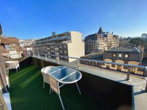 een balkon met een tafel en stoelen op een dak bij Penthouse between lake, Ouchy and city center in Lausanne