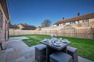 einen Tisch im Hinterhof mit einem Zaun in der Unterkunft Host & Stay - Sunflower Cottage in Seahouses + 22 Fotos
