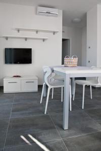 a white dining room with a white table and chairs at Casa Rosa dei Venti in Nago-Torbole