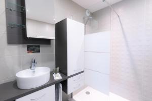 a bathroom with a sink, toilet, and bathtub at Aparthotel Adagio Bâle Mulhouse Aeroport in Blotzheim