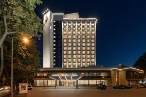 un grand bâtiment avec un parking en face de celui-ci dans l'établissement Premier Hotel Odesa, à Odessa