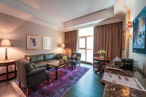 فندق ميلينيوم الدوحة في الدوحة: غرفة معيشة مع أريكة وطاولة