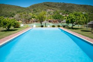 克尼斯纳Brenton Park Cottage 15的一个大蓝色游泳池,背景是一座山