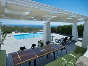 a patio with a table and chairs and a pool at Christou Estate & Villas in Pyrgos