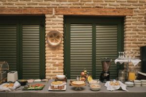 una mesa con comida delante de dos ventanas en Byzantino Hotel, en Patra