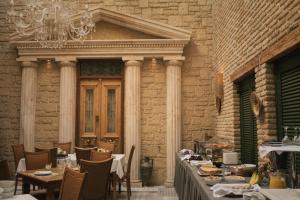 a dining room with tables and chairs and a building at Byzantino Hotel in Patra