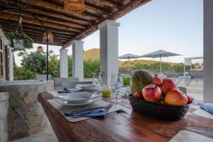 a wooden table with a bowl of fruit on it at Villa Los Naranjos in Cala Llonga