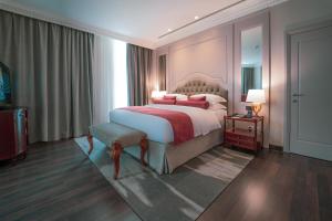 - une chambre avec un grand lit et une grande fenêtre dans l'établissement Millennium Hotel Doha, à Doha
