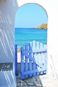 ein blaues Tor mit dem Ozean im Hintergrund in der Unterkunft The charming Beach House, ideal for 4 to 5 people in Ioulis