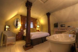 a bedroom with a bed and a tub in a room at Strattons in Swaffham