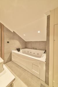 a white bath tub in a bathroom next to a sink at Selini Hotel İstanbul Airport in Istanbul