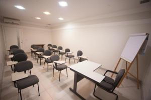 a classroom with chairs and desks and a white wall at Hotel Itajaí Tur - Itajaí Navegantes in Itajaí