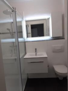 a bathroom with a sink and a toilet and a mirror at Moderne Ferienwohnung in Lippstadt Zentrum in Lippstadt +24 photos