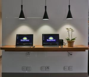 two laptop computers sitting on a wooden counter at Days Inn by Wyndham Rio de Janeiro Lapa in Rio de Janeiro