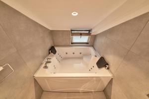 a large white tub in a bathroom with a window at Selini Hotel İstanbul Airport in Istanbul