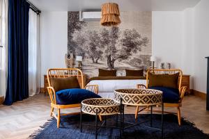 een woonkamer met 2 stoelen en een bed bij Maison Gaspard - Suites et appartements de charme à Saumur in Saumur