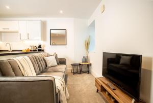 a living room with a couch and a flat screen tv at Luxury Boutique Harbour Apartments - Heart of Torquay - Near Babbacoombe & Beach in Torquay