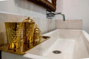 two gold containers sitting on a shelf next to a tub at Maison Gaspard - Suites et appartements de charme à Saumur in Saumur +38 photos