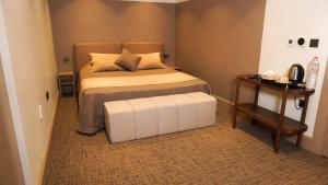a small bedroom with a bed and a table at Selini Hotel İstanbul Airport in Istanbul