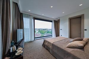 a bedroom with a bed and a large window at Selini Hotel İstanbul Airport in Istanbul