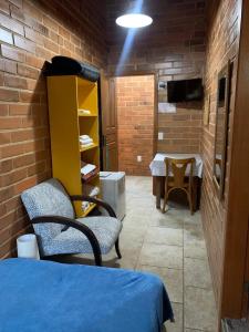 a room with two chairs and a table in a brick wall at Casa João de Barro - São Pedro da Serra in Nova Friburgo