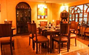 een eetkamer met een houten tafel en stoelen bij La Posada Del Arte in Baños