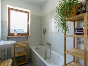 a bathroom with a bath tub and a sink at Ferienwohnung Landurlaub in Bad Feilnbach +42 photos