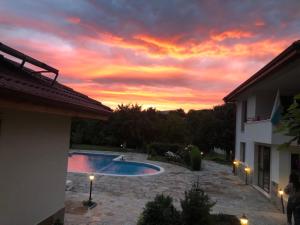 una puesta de sol sobre una piscina en una casa en Mountain View Vacation Home, en Balabanska