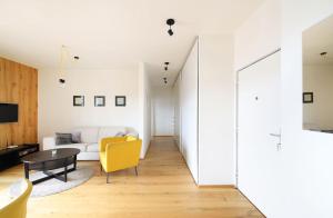 Sala de estar con silla amarilla y mesa en Mountain Apartment Vrchlabi, en Vrchlabí