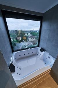 a bath tub in a room with a large window at Selini Hotel İstanbul Airport in Istanbul