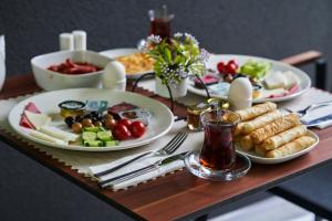 a wooden table with plates of food on it at Selini Hotel İstanbul Airport in Istanbul