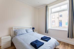 een slaapkamer met een bed met twee blauwe handdoeken erop bij FREE PARKING -2 Bed Apartment, 7mins to City Centre - by StirkMartin in Cardiff
