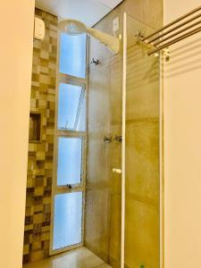 a shower in a bathroom with a window at Pontal Flats in Paraty