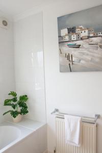 a bathroom with a painting of a beach at Friarscroft Lodge Holiday Home in Wymondham