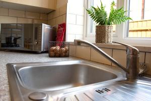 a stainless steel sink in a kitchen with a microwave at Friarscroft Lodge Holiday Home in Wymondham +39 photos