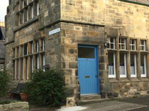 a blue door on the side of a brick building at The Store, harbour holiday cottage in Port Seton