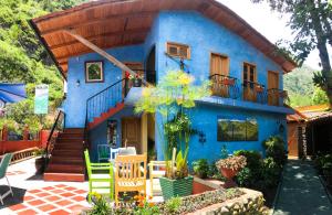 una casa azul con una escalera delante de ella en La Posada Del Arte, en Baños