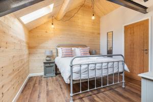 a bedroom with a bed in a room with wooden walls at Kingston Estate in Staverton