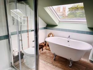 uma casa de banho com uma banheira branca e um WC. em Minster Walk Guesthouse em York