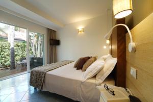 a hotel room with a bed and a balcony at Baia del Godano Resort & Spa in Capo Vaticano