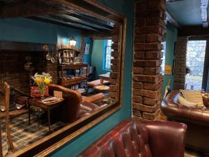 a mirror reflecting a living room with a leather couch at Minster Walk Guesthouse in York