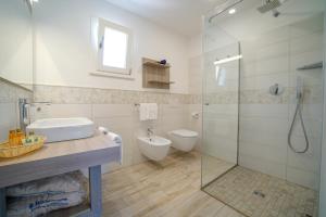 a bathroom with a shower and a sink and a toilet at Baia del Godano Resort & Spa in Capo Vaticano
