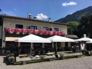 a building with tables and umbrellas in front of it at Restaurant Gästehaus Wiesenheim in Uderns