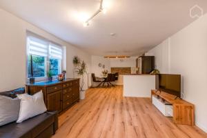 a large living room with wooden floors and a kitchen at Melibokusblick in Bensheim